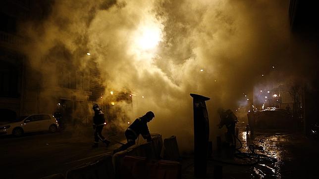 Contenedores ardiendo tras la protesta, en la calle Hermanos Álvarez Quintero, cerca de Génova