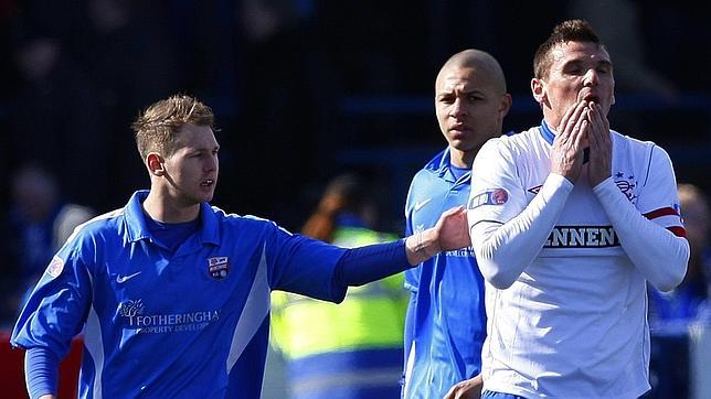 Lee McCulloch, capitán del Rangers, se tapa el rostro tras escuchar el pitido final del partido que cretifica el ascenso de su equipo