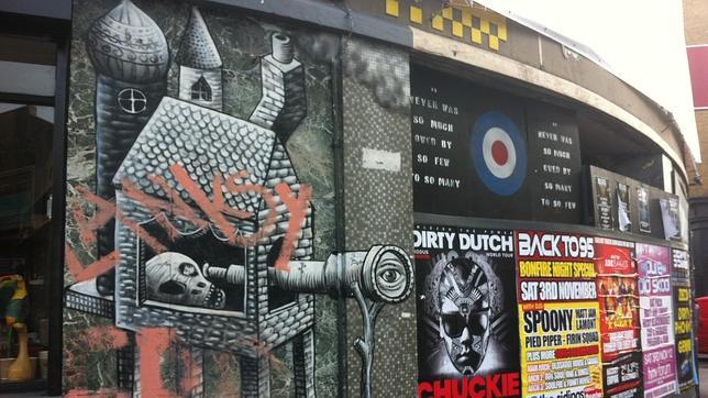 Obra siniestra en blanco y negro de Flemm y, encima, algunos mosaicos amarillos de un grafiti de Invader en la entrada de Rivington Street