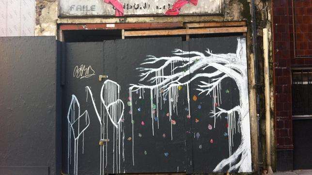 Árbol con lazo rojo del grafitero GIG en Ravey Street