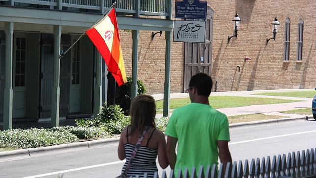 Dos turistas pasean por las calles de Pensacola, donde cuelga una bandera con los colores de España
