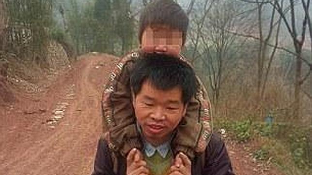 Un hombre carga con su hijo discapacitado todos los días durante 28 km. para llevarlo a la escuela