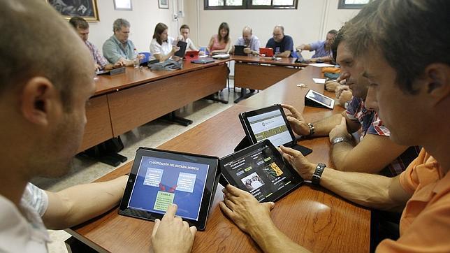 Un grupo de personas trabaja con distintos dispositivos móviles