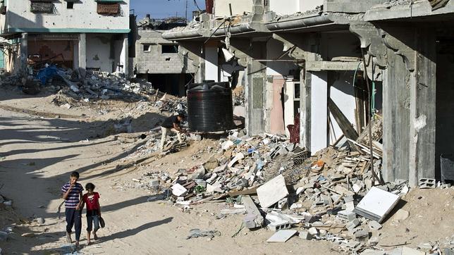 Dos muchachos pasean por una devastada calle de Shejaiya, en Gaza
