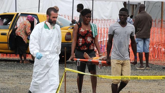 Personas transportando a un niño enfermo hacia el hospital en Monrovia