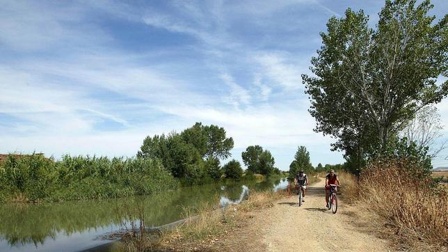Dos ciclistas ruedan a orillas del canal