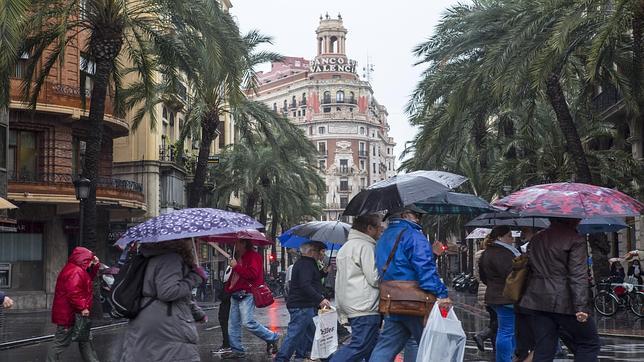 Varias personas se protegen de la lluvia que cayó este martes sobre la ciudad de Valencia