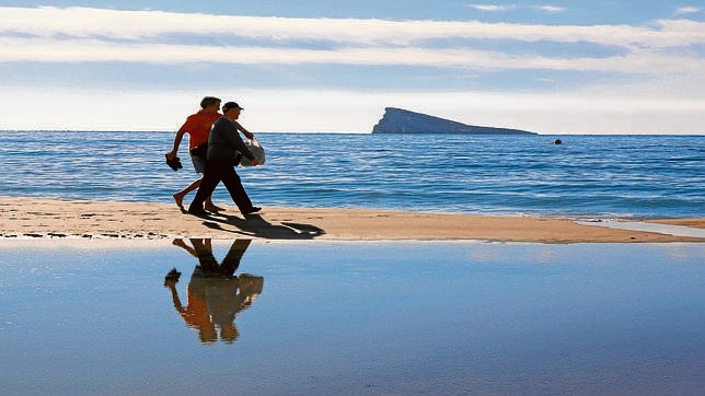Dos turistas pasean por una de las playas de Benidorm