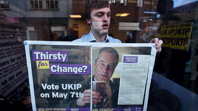 Un hombre cuelga un cartel de apoyo a Farage