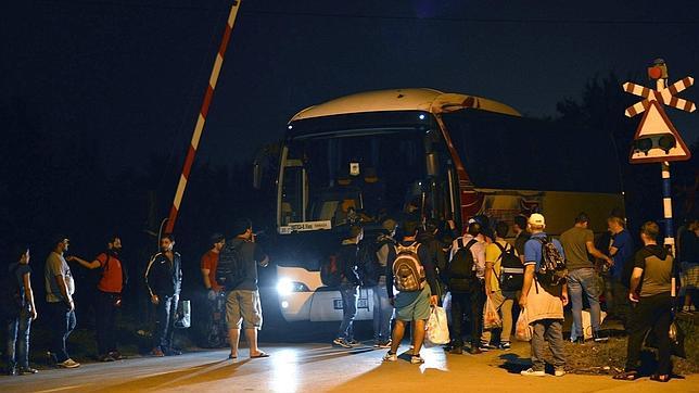 Varios inmigrantes congregados en la frontera de Serbia con Hungría cerca de Horgos (Serbia) en la madrugada de hoy 26 de agosto de 2015