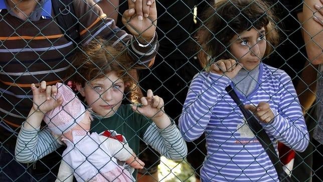 Dos niñas refugiadas esperan para registrarse tras haber cruzado la frontera entre Serbia y Croacia en Tovarnik, Croacia