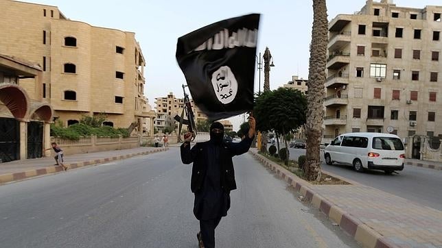 Un yihadista con la bandera de Estado Islámico en la ciudad siria de Raqqa