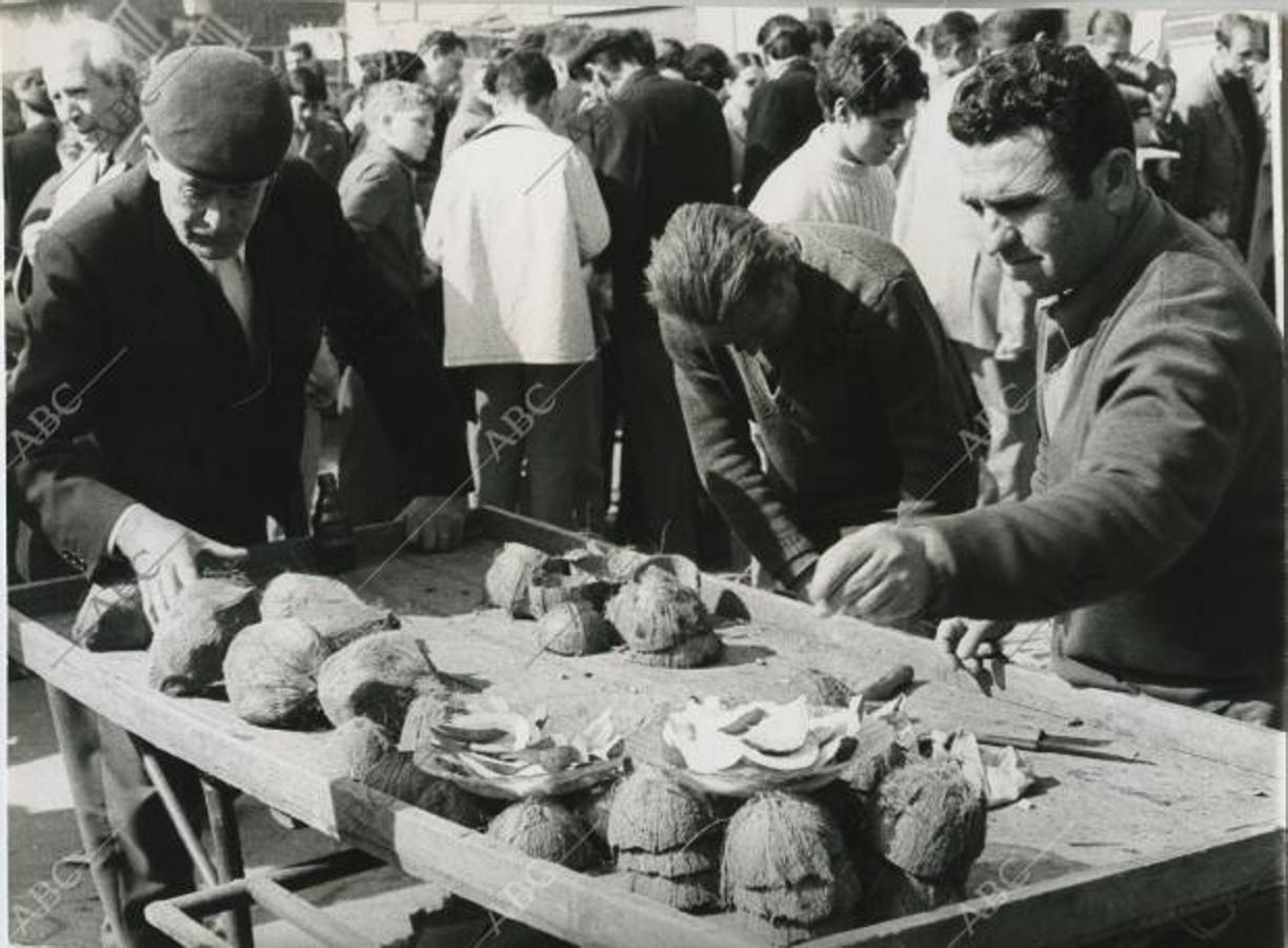 Un vendedor ambulante de trozos de coco atendiendo a un cliente en los 70