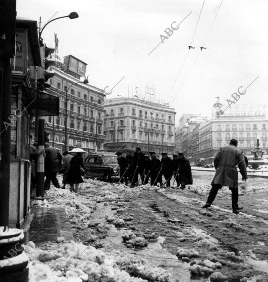 Los servicios de limpieza en la Puerta del Sol, tras la gran cantidad de nieve caída el 11 de enero de 1960