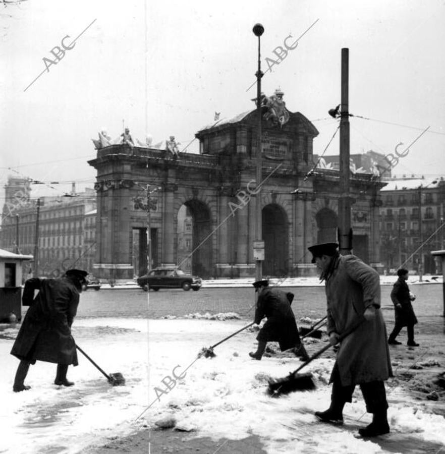 Los servicios de limpieza quitan la nieve de la Puerta de Alcalá tras una nevada de 1963