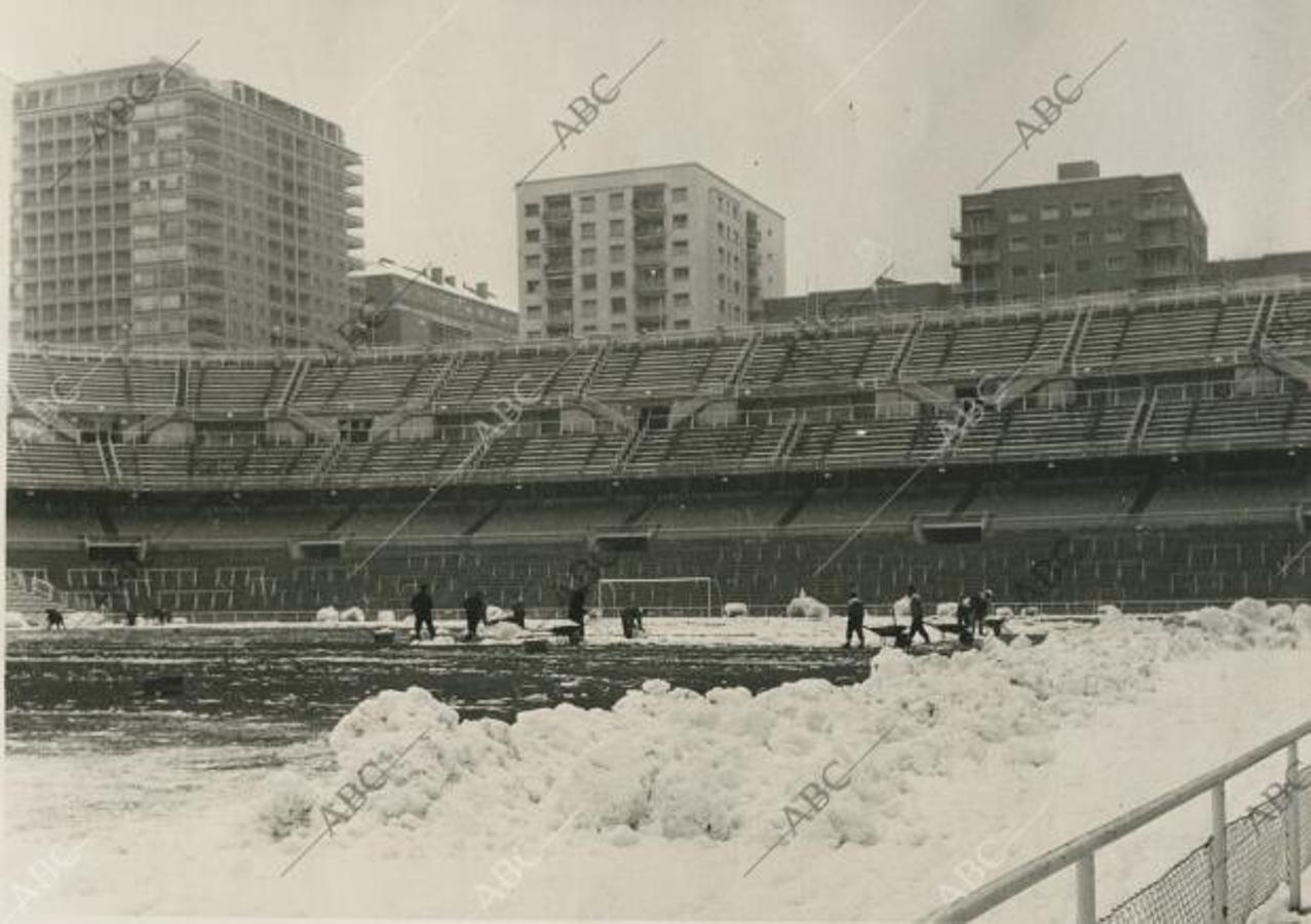 Los operarios del Santiago Bernabéu limpian la nieve del terreno de juego el 1 de febrero de 1963