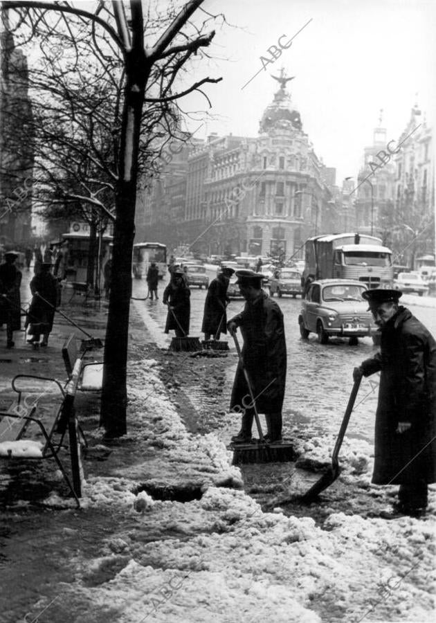 Los trabajadores municipales limpian la nieve de la calle Alcalá en enero de 1967