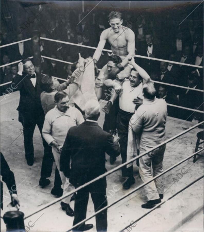 Georges Carpentier defiende su título de campeón los pesos pesados, de la Unión Europea de Boxeo, ante Joe Beckett en el Holborn Stadium el 4 de diciembre de 1919. El francés, que venció por KO en el primer asalto, es llevado a hombros