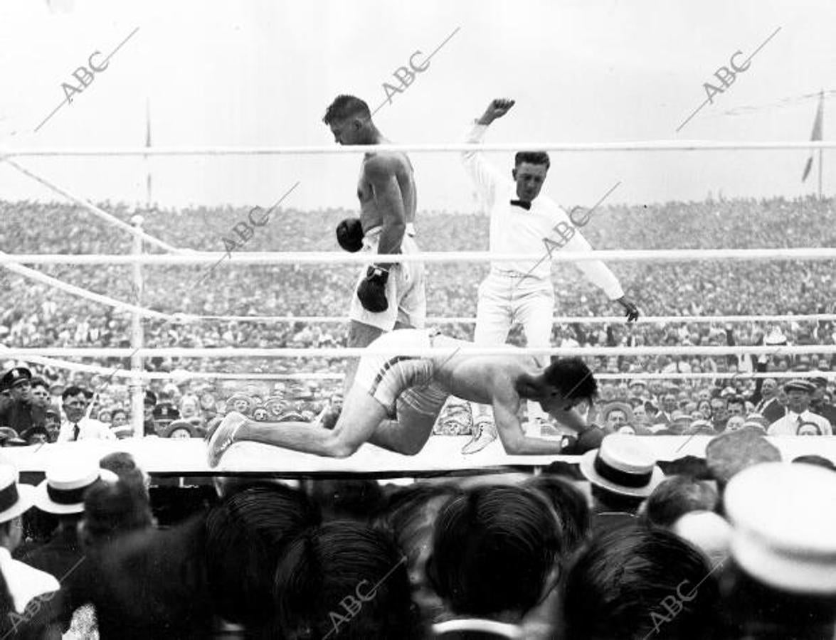 Carpentier-Dempsey, por el campeonato mundial de los pesos pesados de la Asociación Nacional de Boxeo, celebrado en el Boyle's Thirty Acres de Jersey City el 2 de julio de 1921. Aquí, el momento en el que el campeón francés, cae al suelo vencido por el campeón norteamericano, y el árbitro cuenta los segundos para proclamar el triunfo de Dempsey 