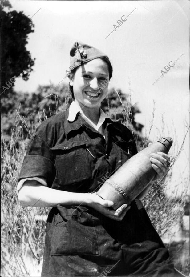 Maruja Tomico, miliciana del puente de Vallecas que actuaba como artillera en una pieza del 10 1/2 en el frente de Guadarrama, mostrando el proyectil que cayó a su lado y no explotó, gracias a lo cual salvó la vida. 