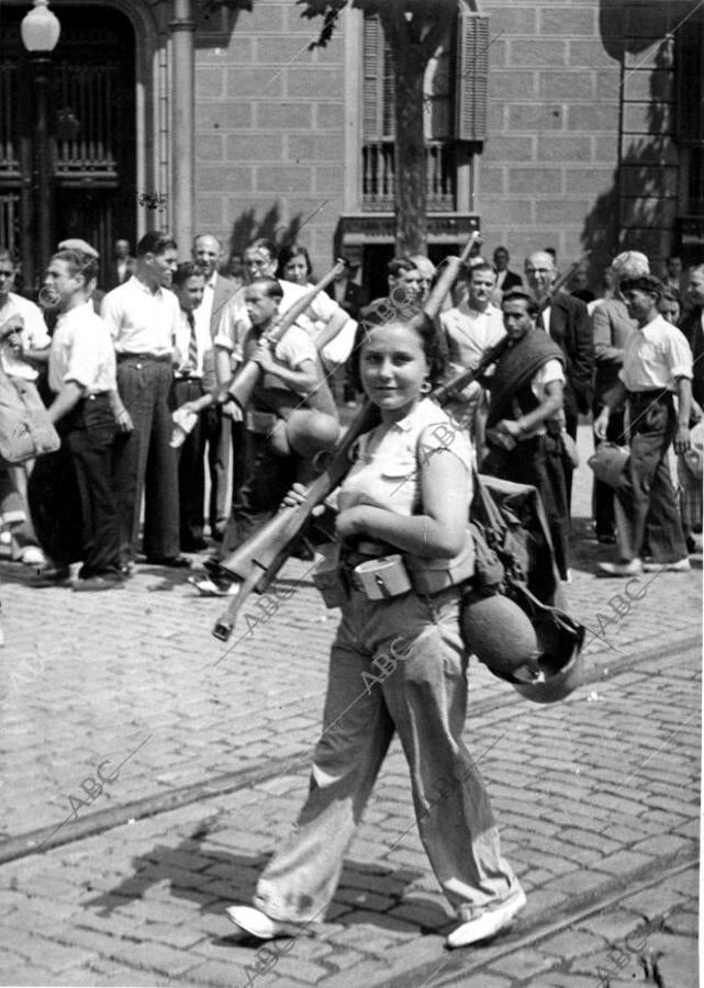 Una miliciana desfilando con su columna por las calles de Barcelona, camino del frente aragonés