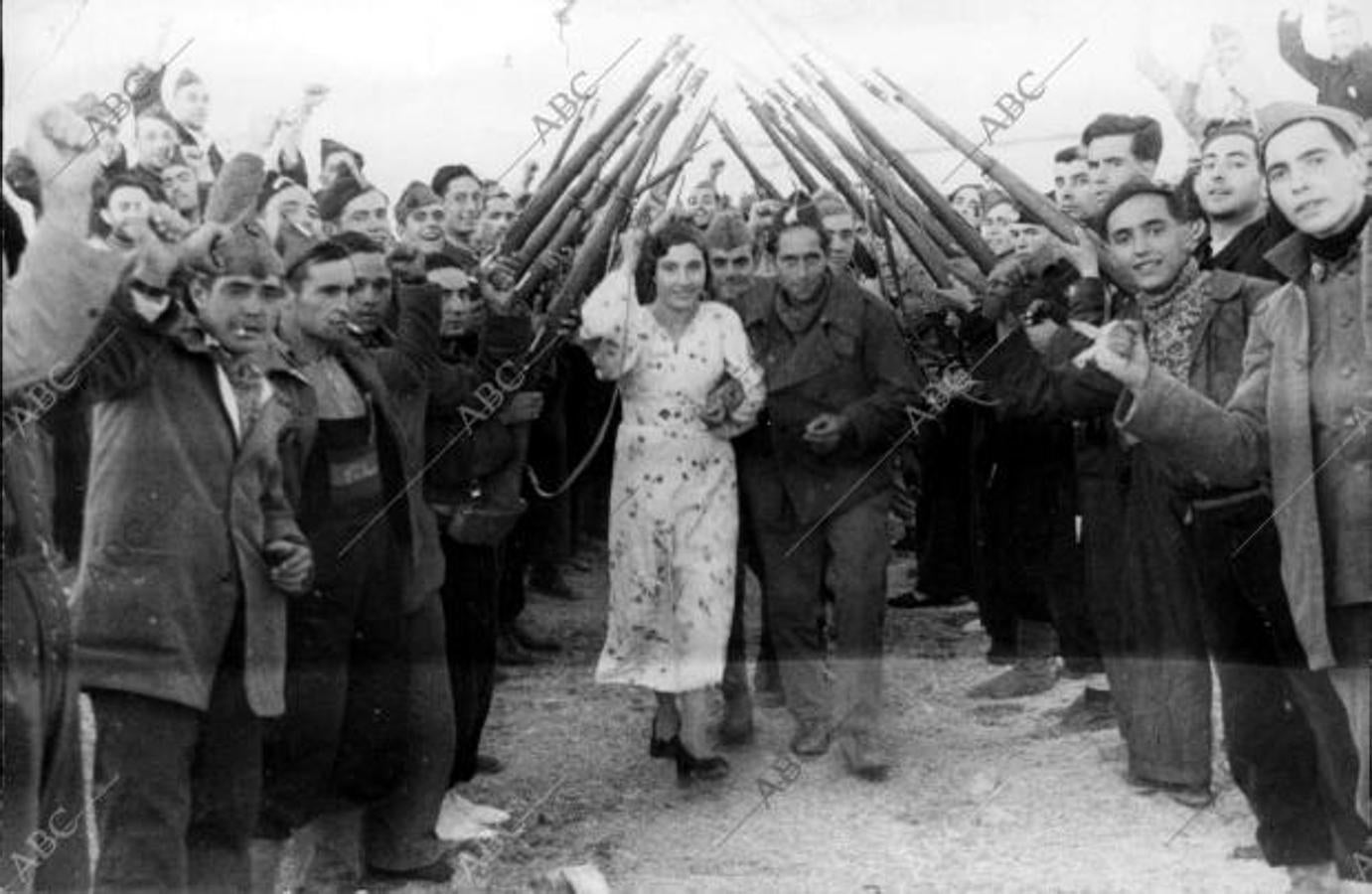 Octubre de 1936. Boda en el frente de los milicianos Julio Triguero y María de la Torre, del Batallón Primero de Mayo. Una vez terminada la ceremonia de su enlace, los recién casados pasan por debajo del arco de los mosquetones y bayonetas de sus compañeros