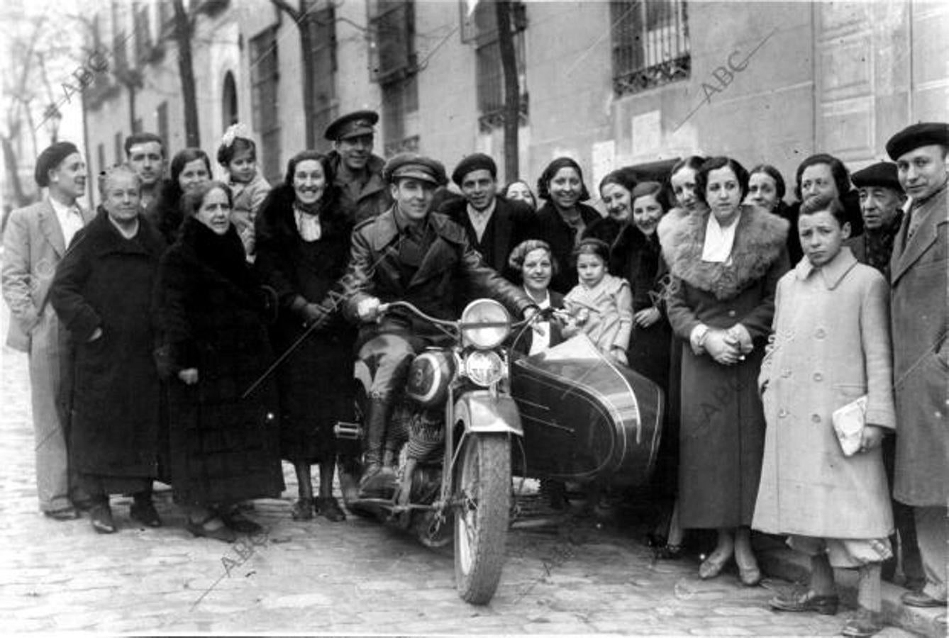 Madrid, febrero de 1937. El vigilante de carreteras, Arsenio López, utiliza su moto para asistir a la ceremonia de su boda con Benita Galcote, quien aparece en la fotografía junto a su nuevo marido y los invitados, una vez terminado el acto