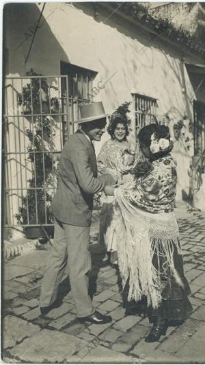 Un hombre y una mujer vestida de flamenca se preparan para ir a la Feria en 1934