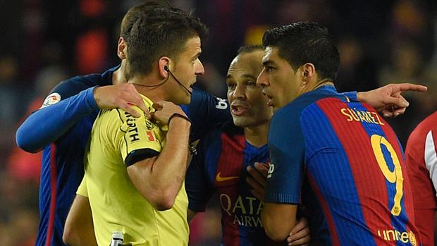 Los jugadores del Barça rodean al árbitro