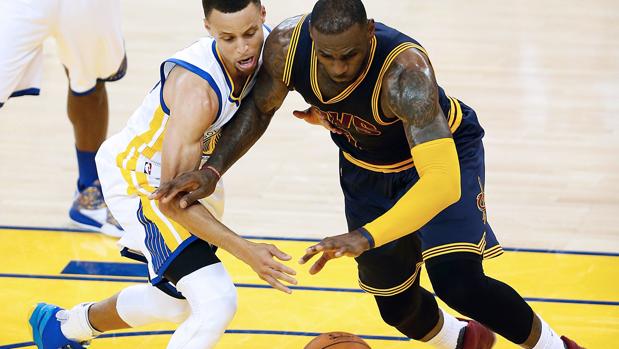 Stephen Curry (Warriors) pelea por el balón con LeBron James (Cavaliers)