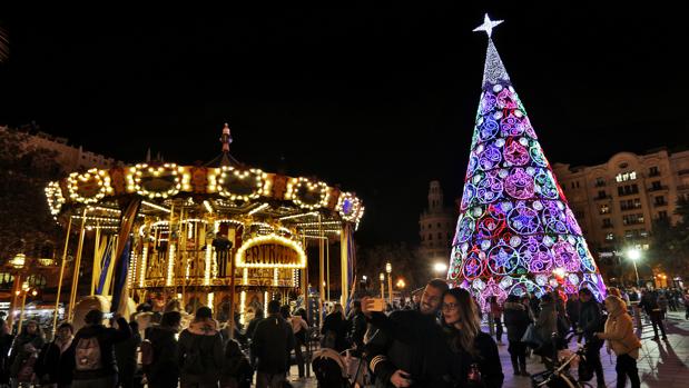 La plaza del Ayuntamiento de Valencia, iluminada con luces de Navidad y con la pista de hielo