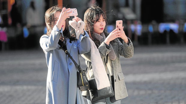 Dos turistas asiáticas toman fotografías en la Plaza Mayor