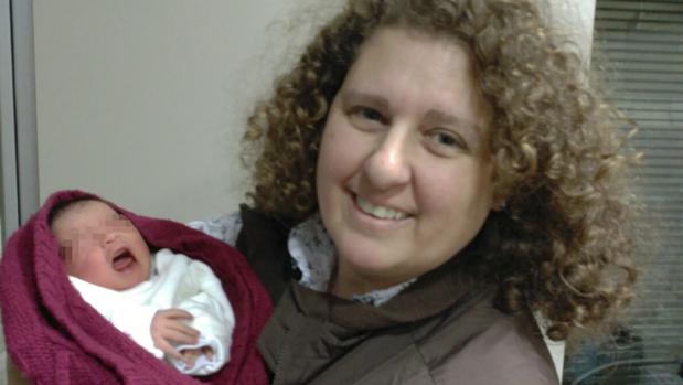 Julia Sánchez abriga a la pequeña con su chaqueta después de recogerla de la puerta de la iglesia