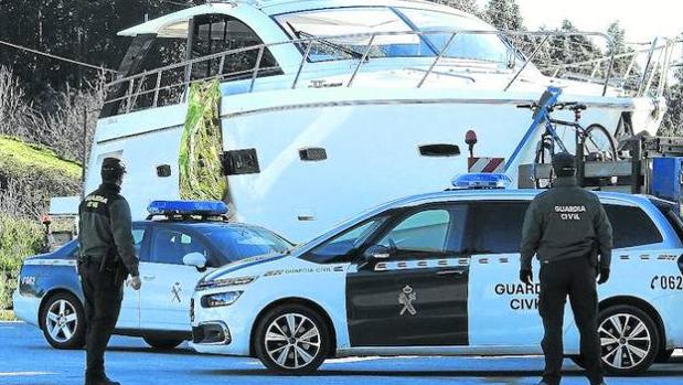 Agentes de la Guardia Civil custodian el cuerpo de la víctima que cuelga del yate