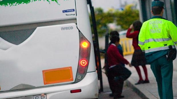 Agente de la Guardia Civil junto a un autobús escolar