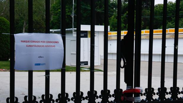 Las casetas de la Feria del Libro en El Retiro, tras un cartel que advierte del cierre
