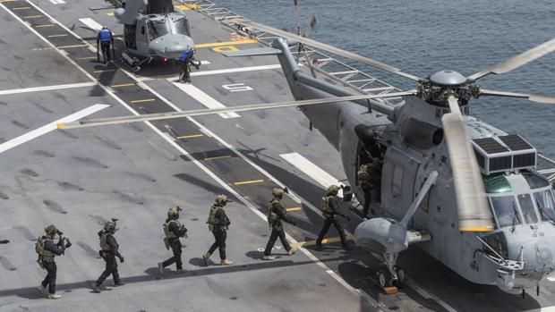 Varios militares realizan unas maniobras sobre un portaviones en la base militar de Rota