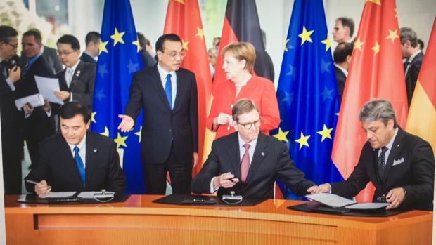 Luca de Meo (d.), Heizzmann (c.) (VW China) y An Jin (Jac) firman el acuerdo en presencia de Merkel y Li Keqiang, primer ministro chino