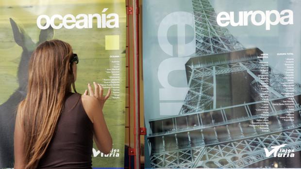 Imagen de una mujer delante de una agencia de viajes
