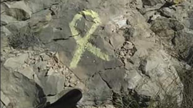 Lazo amarillo pintado sobre la roca en la Sierra del Cid de Petrer (Alicante)