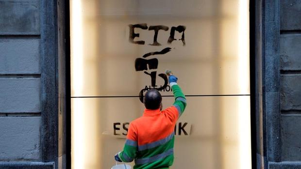 Un operario borra una pintada con el anagrama de la banda terrorista ETA