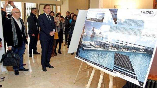 El presidente Puig junto a una imagen de la zona portuaria donde se construirá el nuevo edificio con forma de cubierta del barco