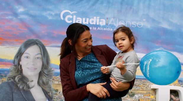 Claudia Alonso, con su hija pequeña, Victoria, en el stand del PP en el paseo de la Vega