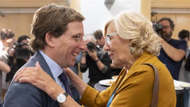 Manuela Carmena abraza al nuevo alcalde de Madrid, José Luis Martínez-Almeida, en el pleno de Cibeles