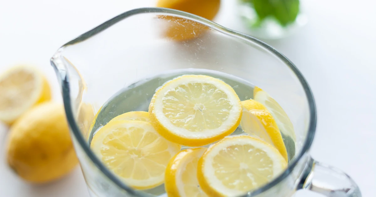 Buen Día! Agua De Limón En Una Jarra O Jarra De Vidrio Y Vertida En Un  Vaso. Agua De Limón Rica En Vitamina C Fresca Para Energía Foto de archivo  - Imagen