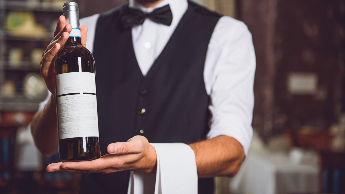 Smiling man holding bottle with alcohol