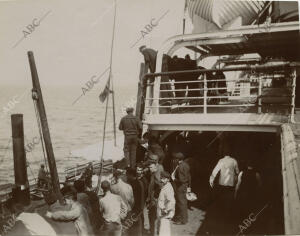 Los marineros repatriados esperando el transbordo a las gabarras, en el puerto...