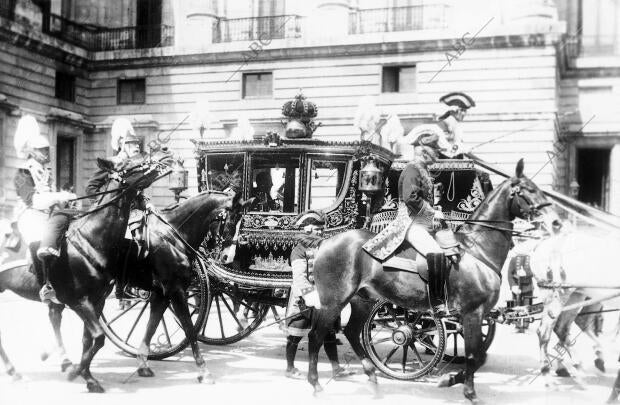 Los Reyes en la carroza De "la Corona", al salir de palacio acompañado de su...