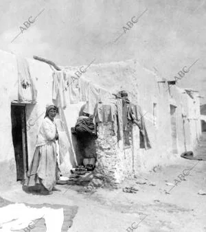 Una judía Tendiendo ropa A la puerta de su Vivienda