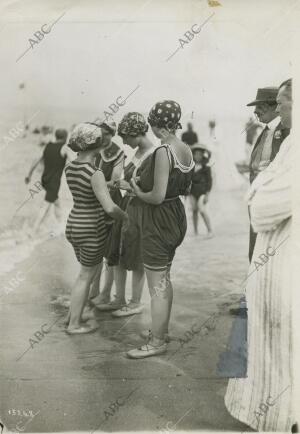 Un grupo de bañistas en la playa disponiendose para entrar al agua